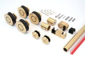 Set of brass and black sliding door hardware components.