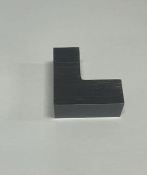 Black L-shaped object on a plain surface.